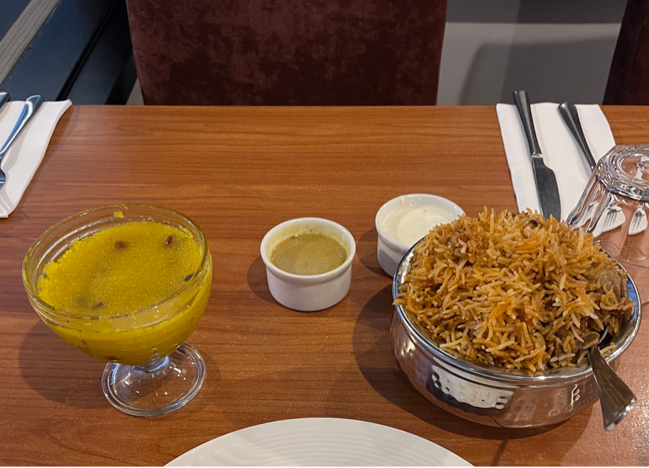 Biryani served with salan, raita and kesari