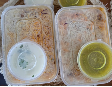 Takeaway biryani packs with salan and raita